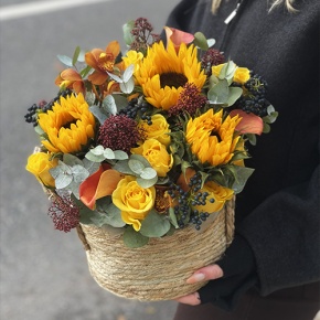 Композиция в сумке "Тональность" из подсолнухов, калл, ягод вибирнума, лимонных роз, скиммии и орхидеи в Одинцово